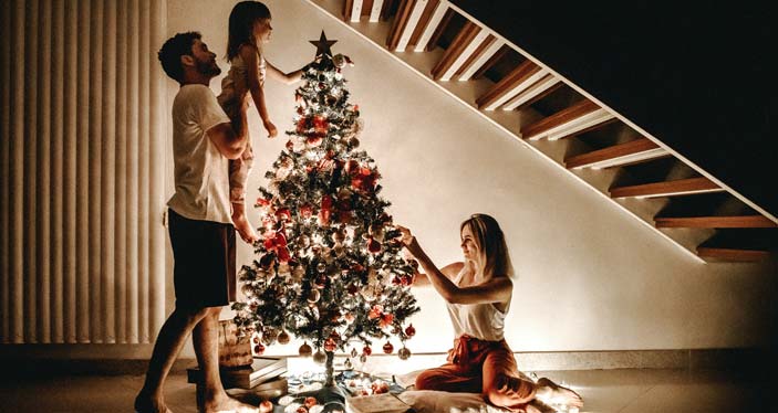 family hanging star on christmas tree
