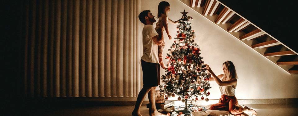 family hanging star on christmas tree