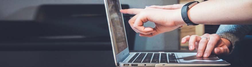 fingers pointing to the cheapest broadband deal on a laptop screen